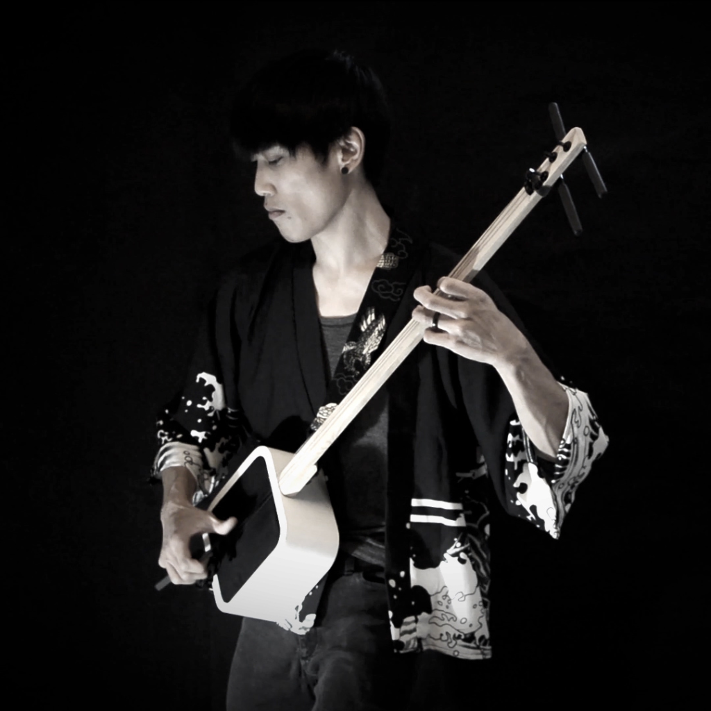 Photo of Jero11 playing his custom-made shamisen